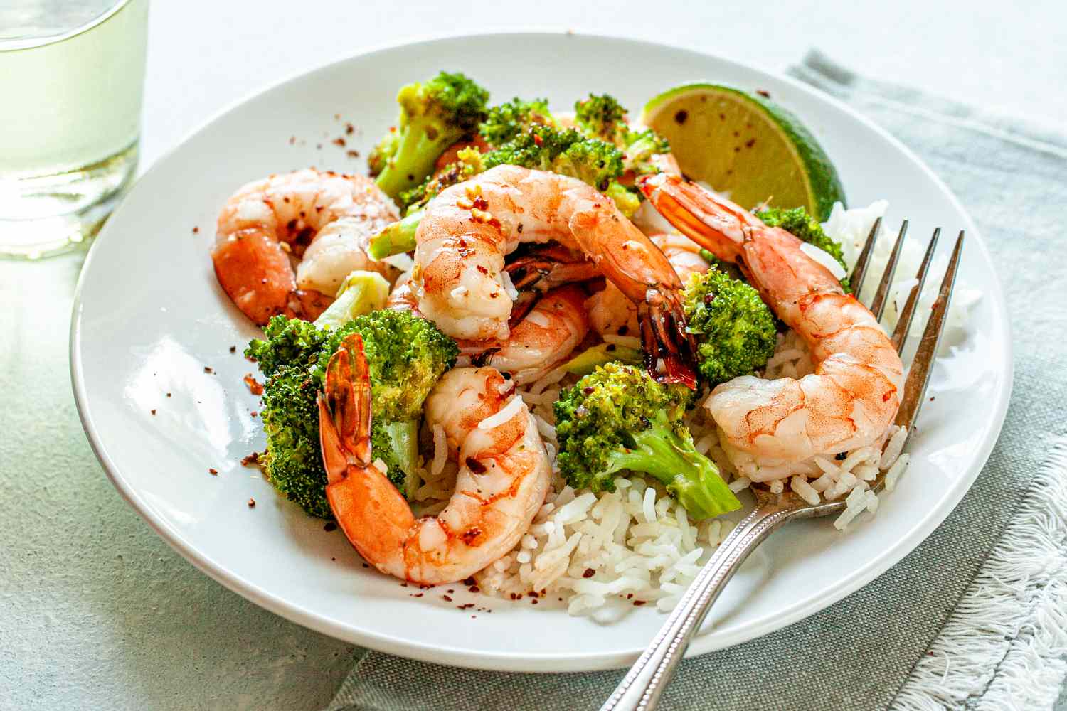 Spicy Honey Roasted Shrimp and Broccoli on a white plate with a fork.