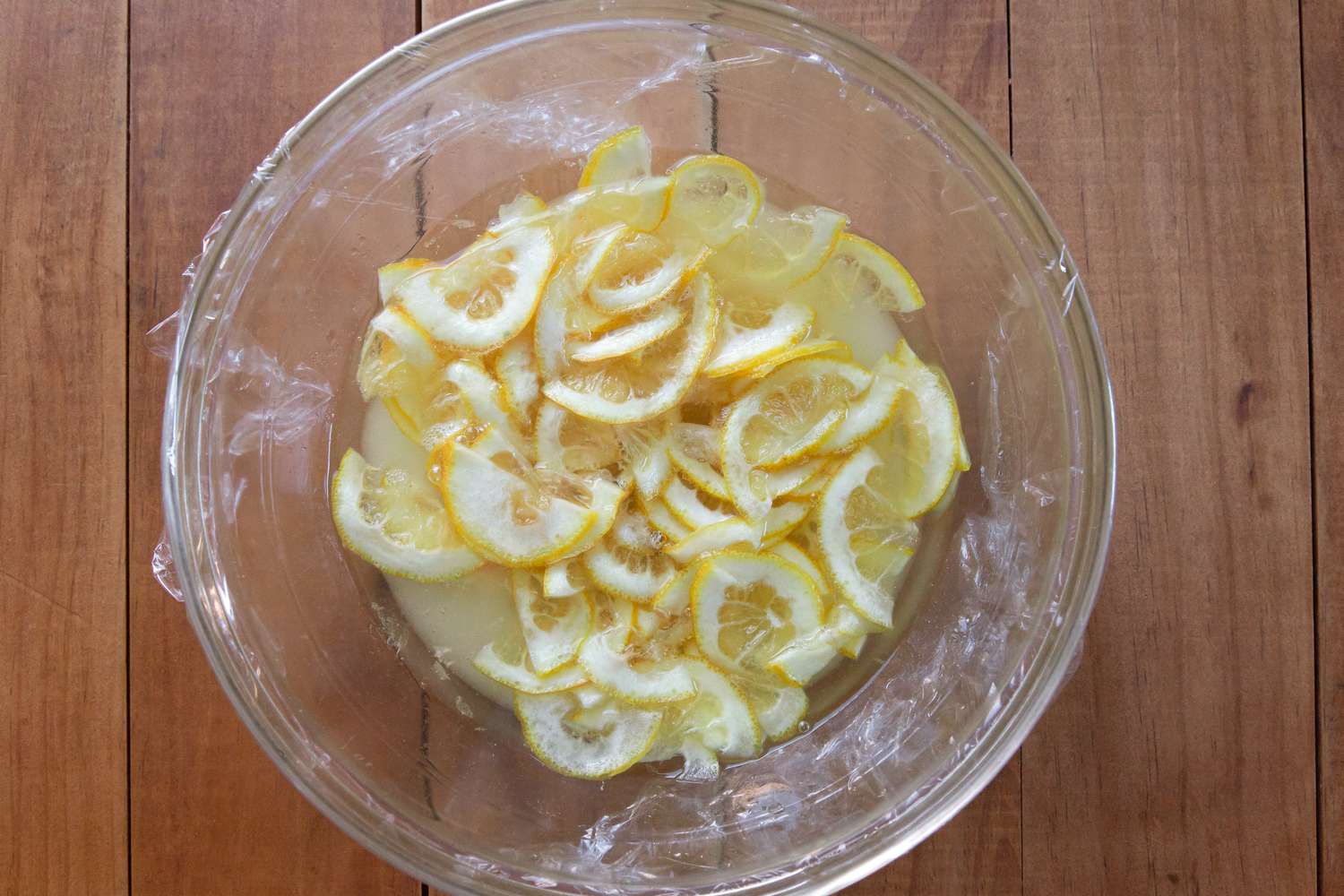 A bowl of sliced lemons macerating in sugar to make a Lemon Shaker Pie Recipe.