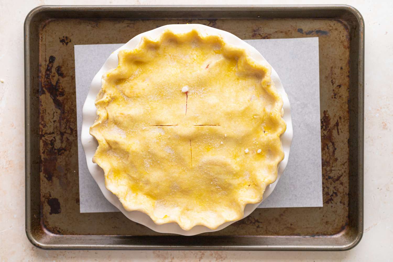 A stone fruit and berry pie on a baking sheet before baking.