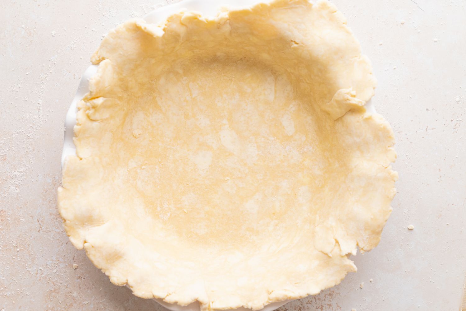 Pie dough set in a pie plate to make summer peach and raspberry pie.