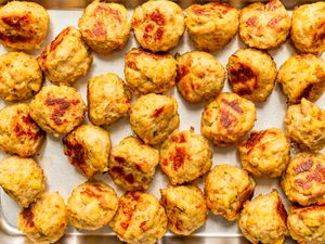 Overhead view of a metal baking sheet full of 3-ingredient chicken meatballs