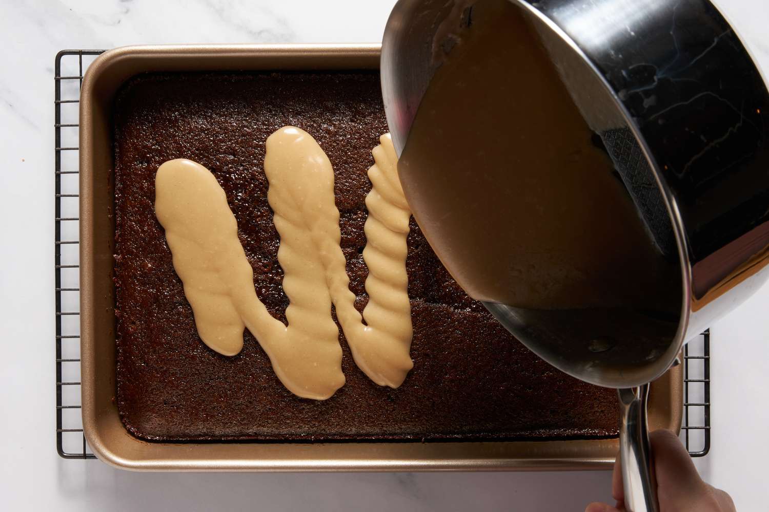 Dr. Pepper icing poured onto the Dr. Pepper cake in the baking pan