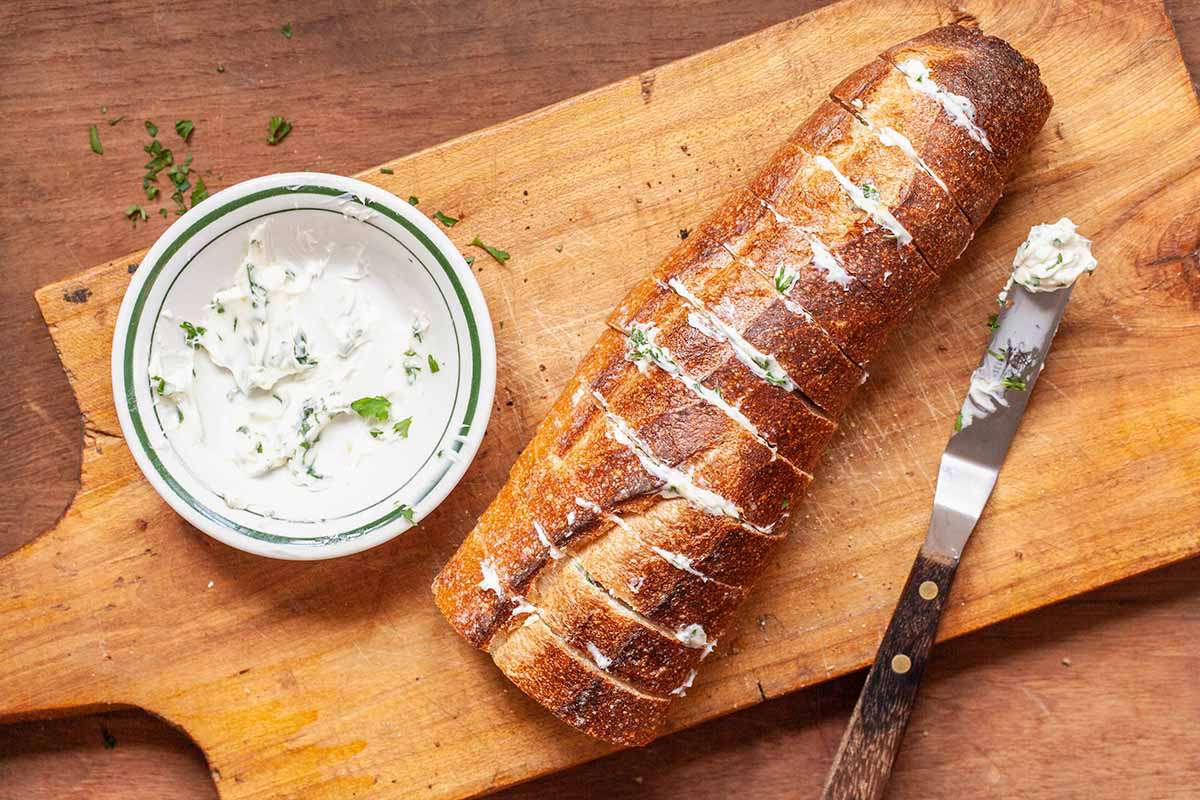 Homemade garlic bread cut in vertical slices with butter in between