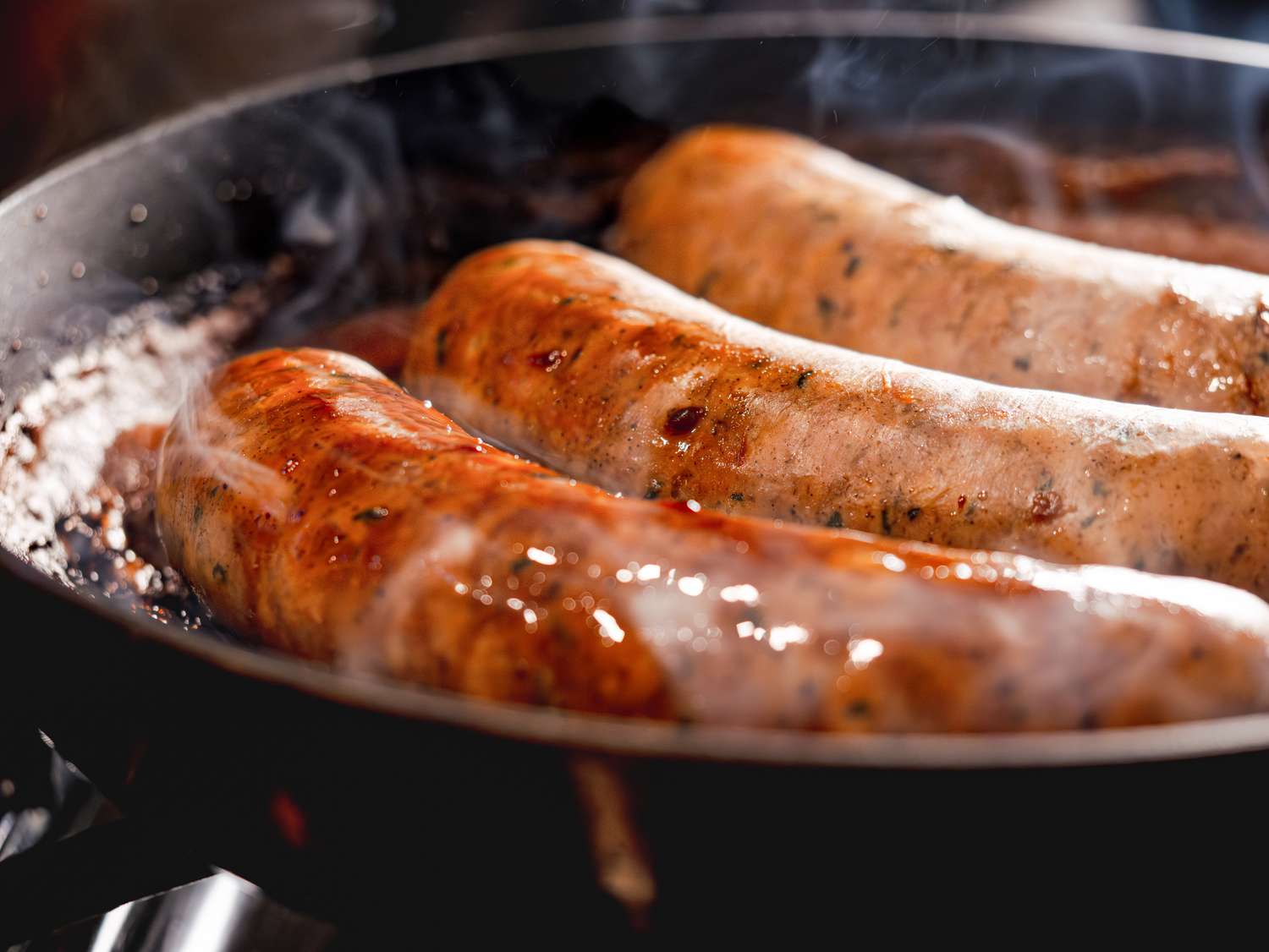 Sausages cooking in a skillet
