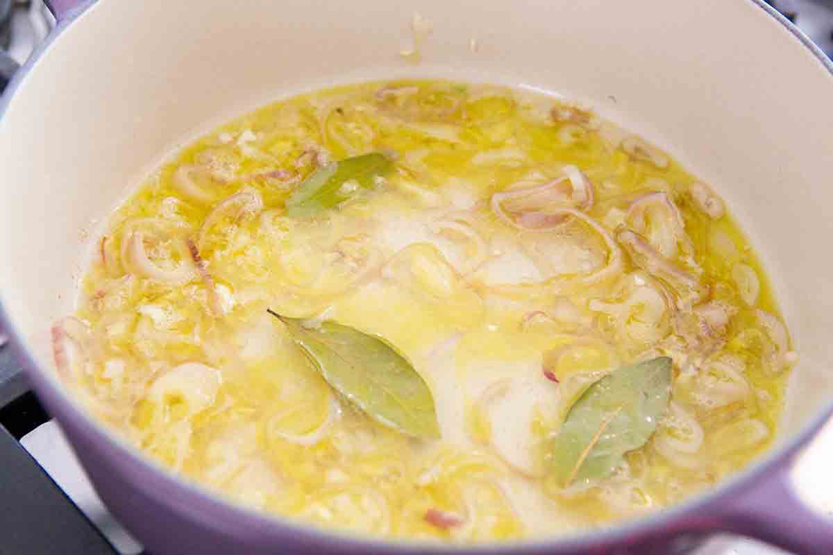 add wine and bay leaves to shallots in a pot