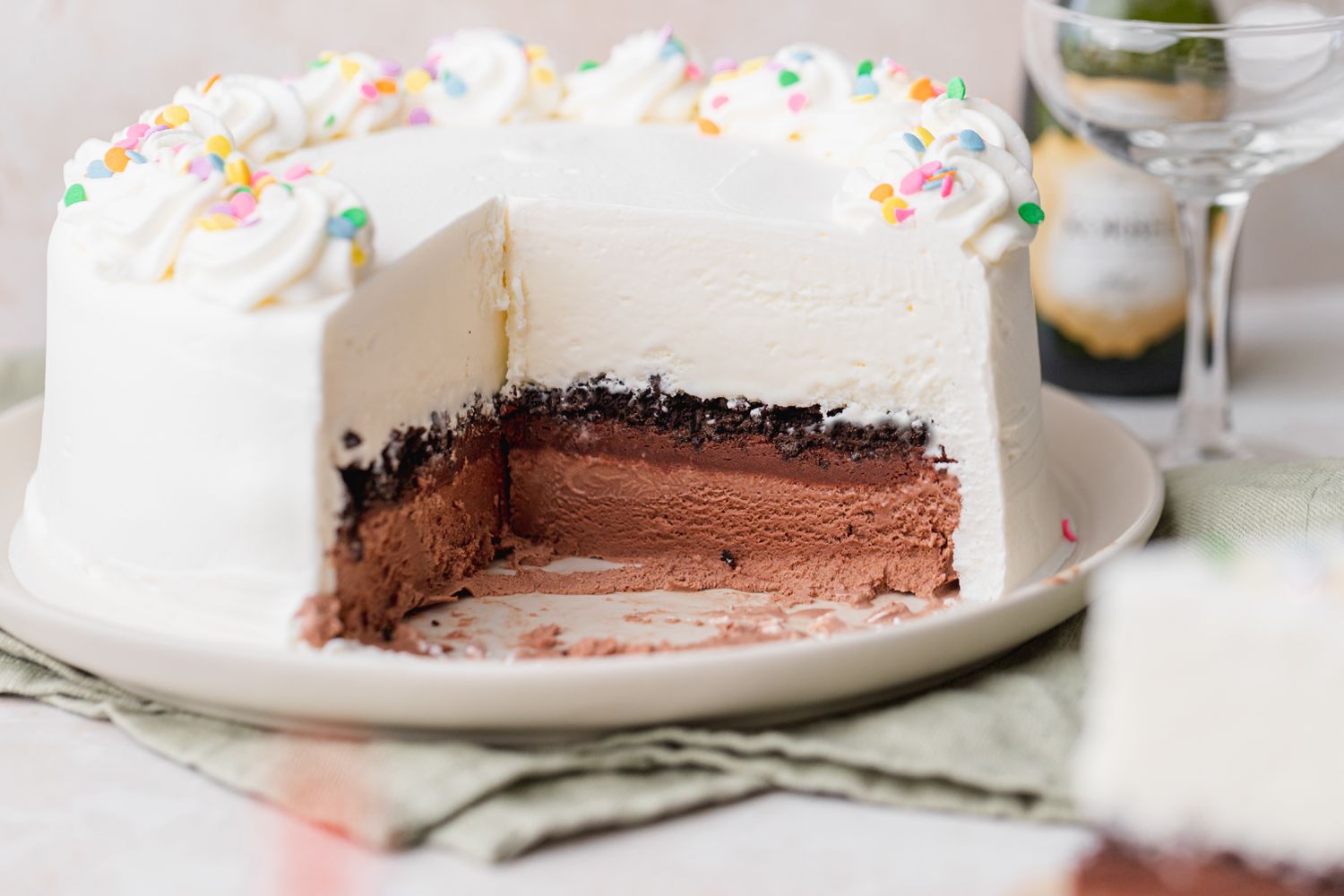 Ice Cream Cake That Was Cut Into on Plate with a Glass in the Background