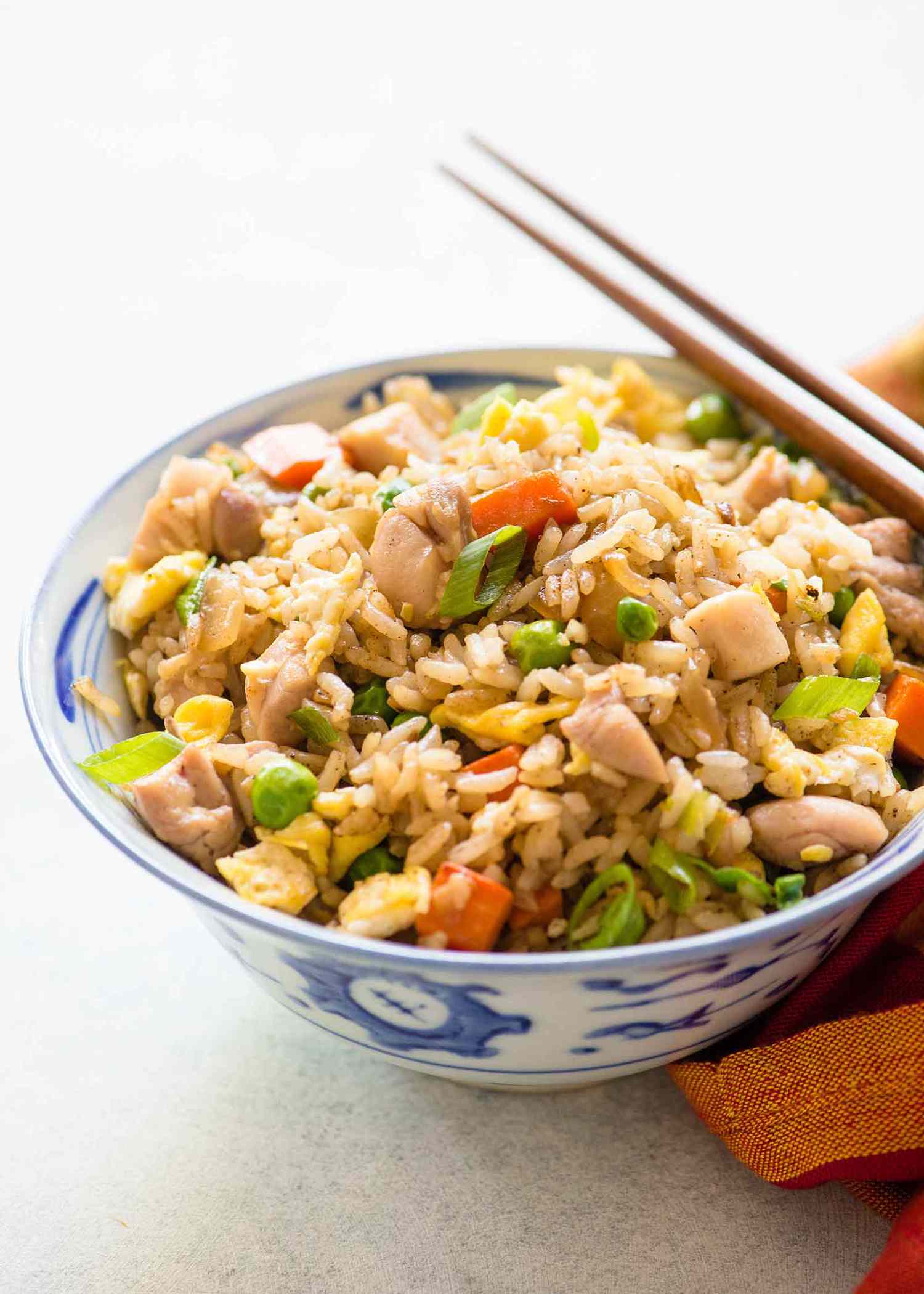 A bowl of chicken fried rice with chopsticks