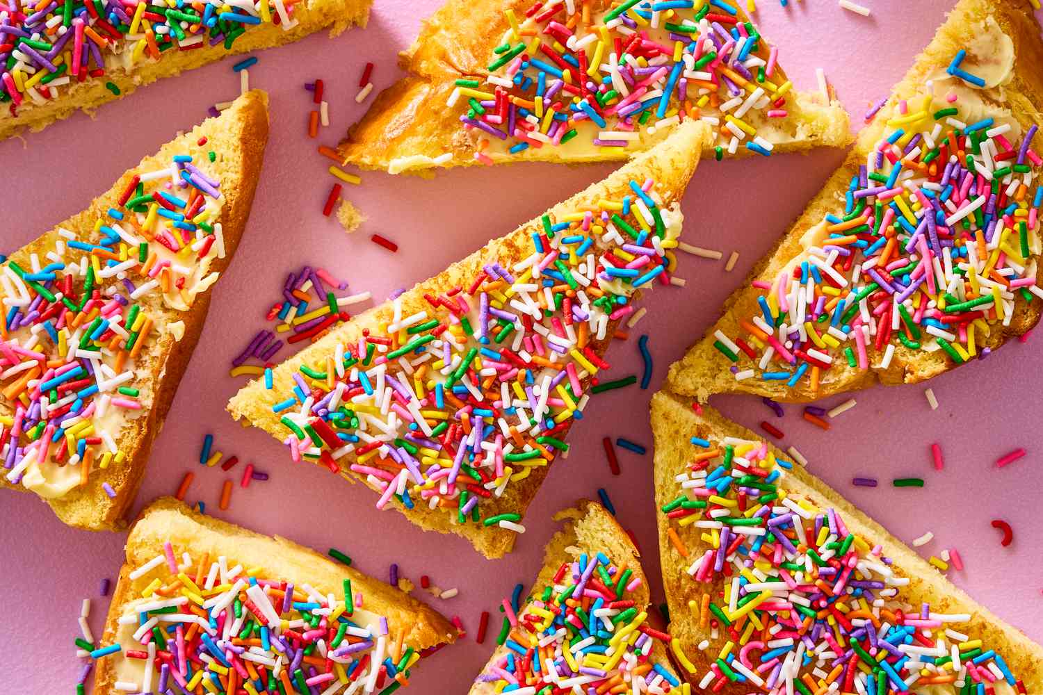 Triangular slices of toast with sprinkles spread on top, arranged on a flat surface