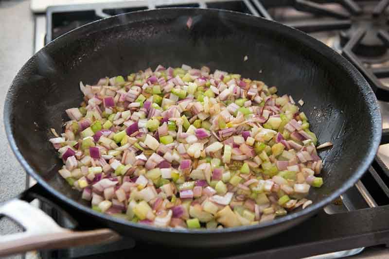 sautéed celery and onion in black frying pan 