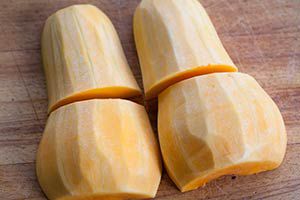 Peeled butternut squash cut into fourths