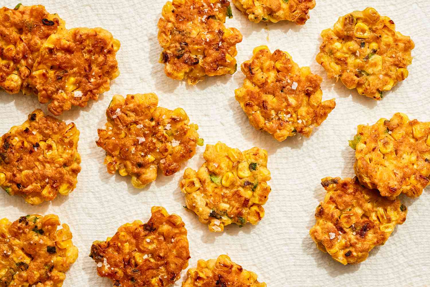 Crispy corn fritters laid out on a surface