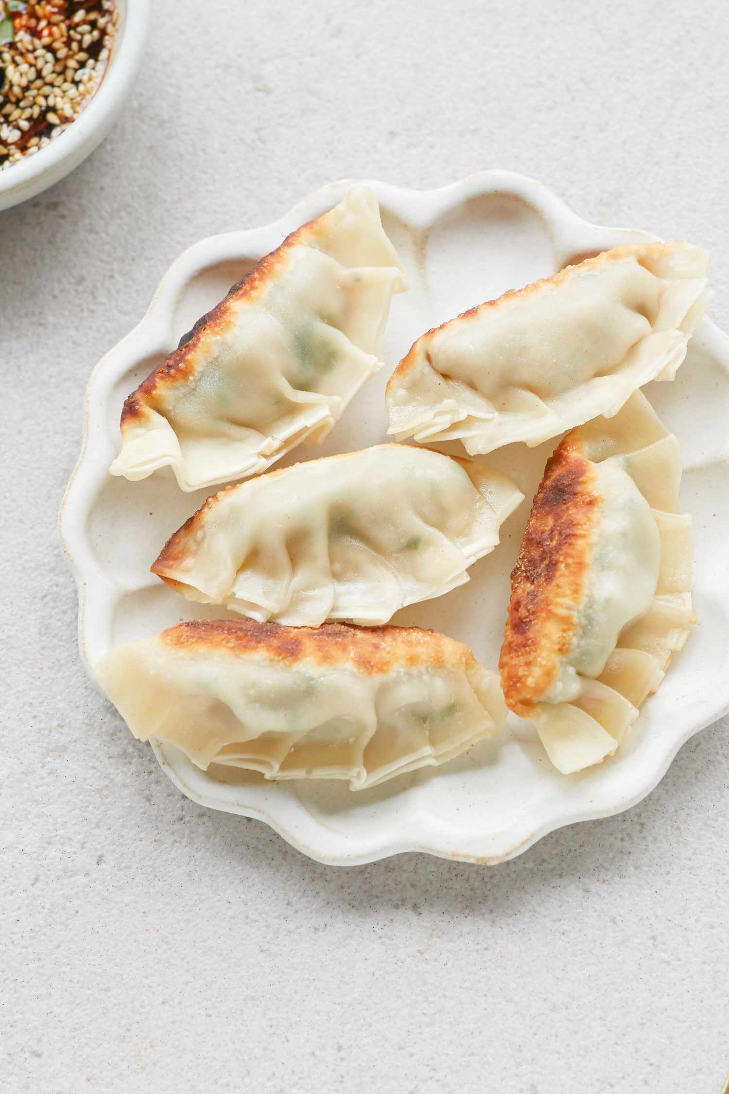 Overhead view of Korean pork and chives dumplings on a plate.