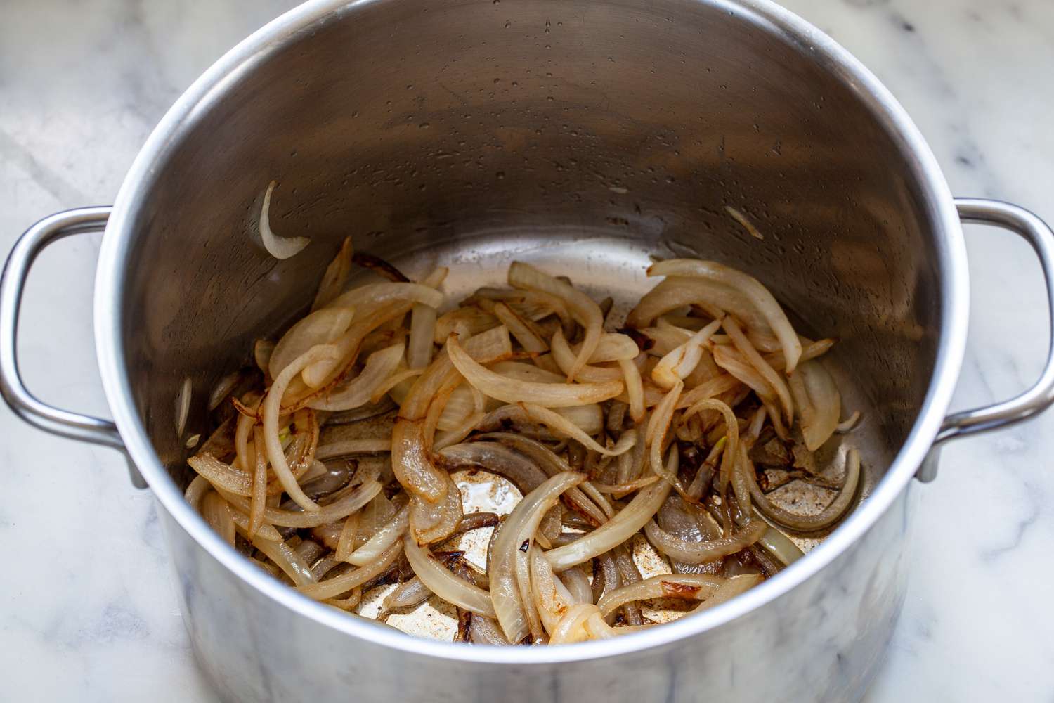 A large stockpot with sliced onions to show how to make collard greens.