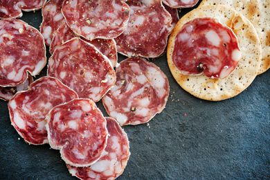 Sliced soppressata and crackers on slate board