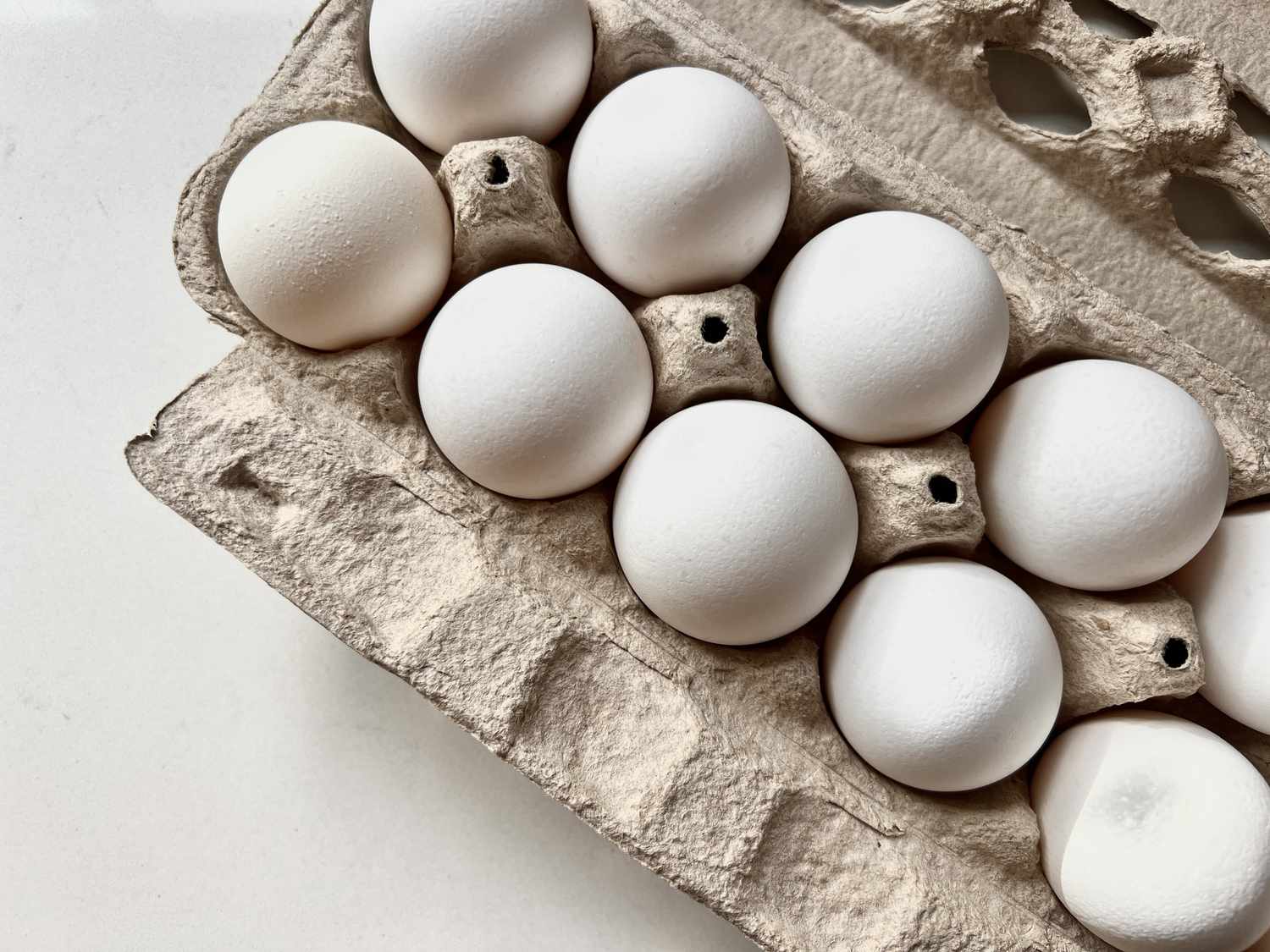 Overhead view of a carton of eggs on a white background