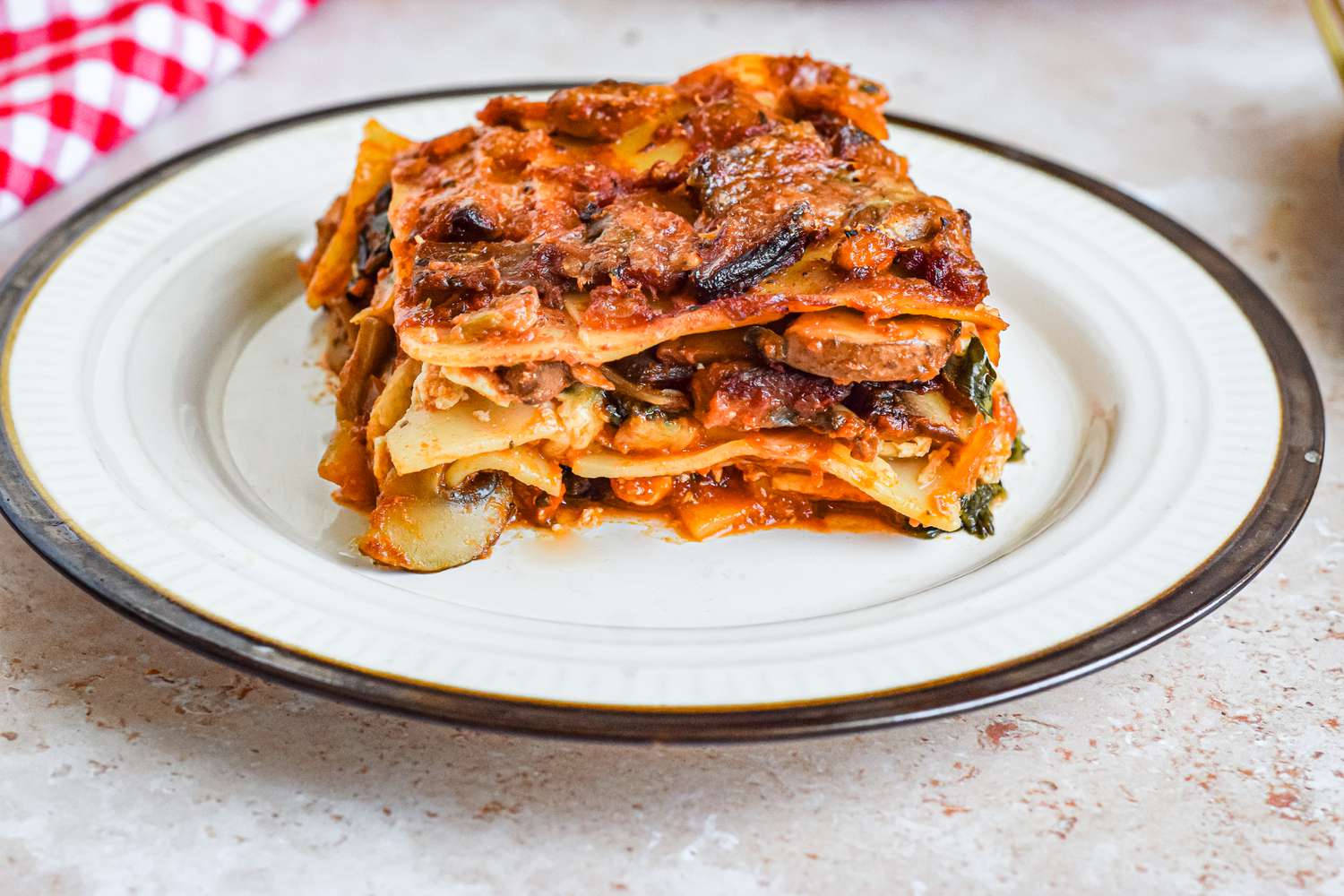 Slice of Vegetarian Spinach and Mushroom Lasagna on a white Plate