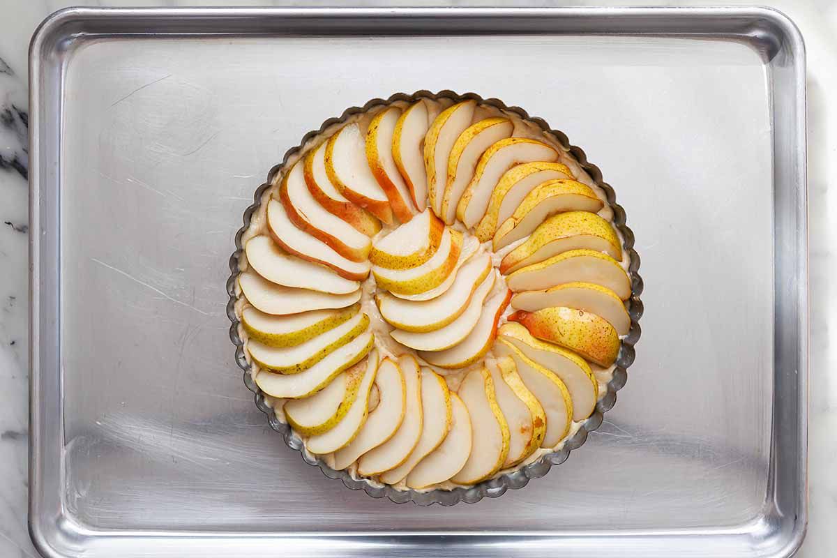 Easy Pear cake in a fluted tart tin with sliced pears arranged on top