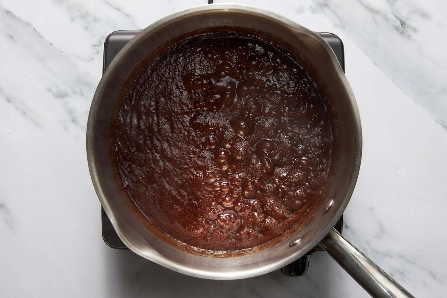Chocolate fudge boiling on the stove for bumpy cake recipe