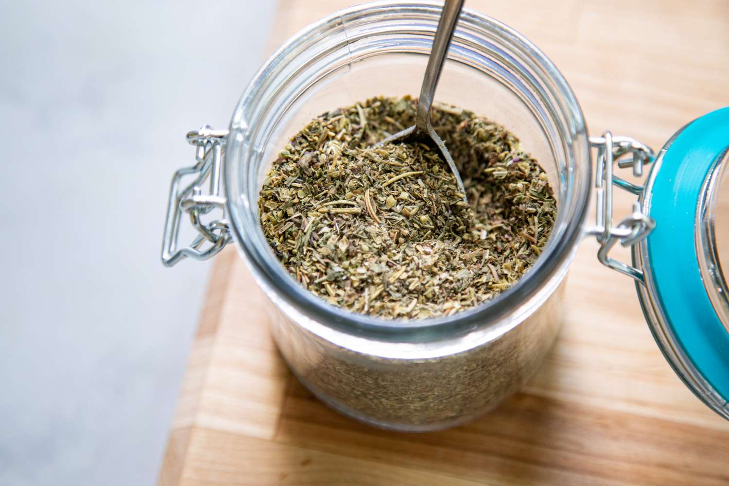 Italian Seasoning in a Jar Sitting on a Cutting Board
