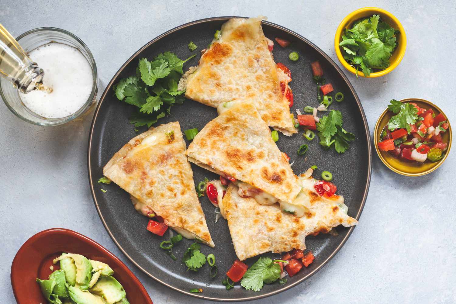 A cheese quesadilla on a plate with toppings.