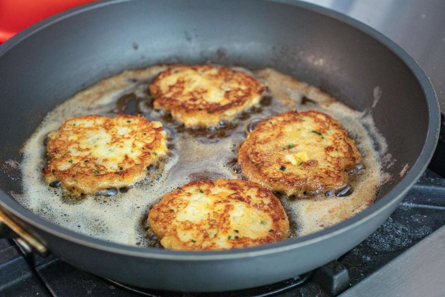 Pan frying mashed potato pancakes with cheddar.