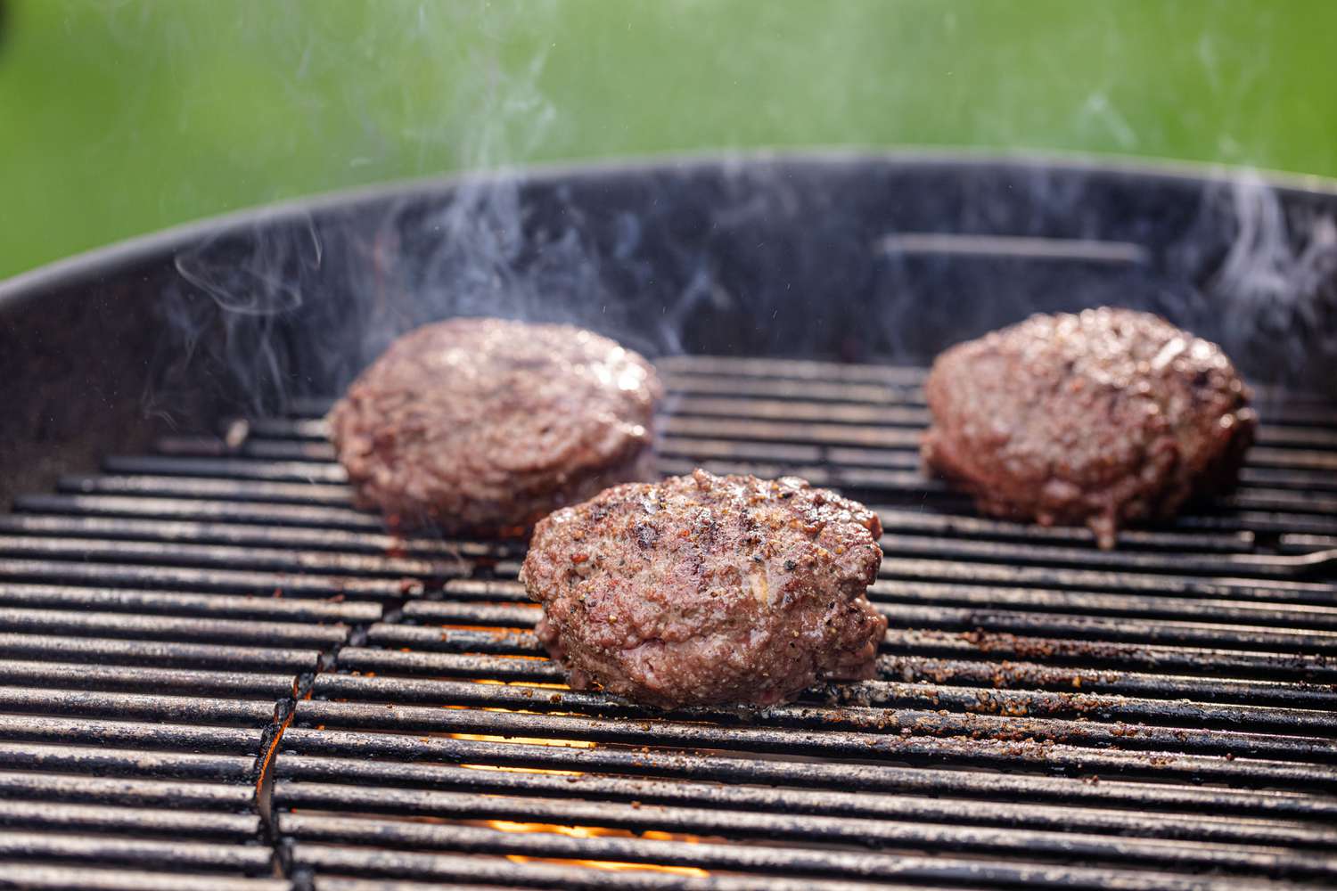 Burgers steaming on the grill