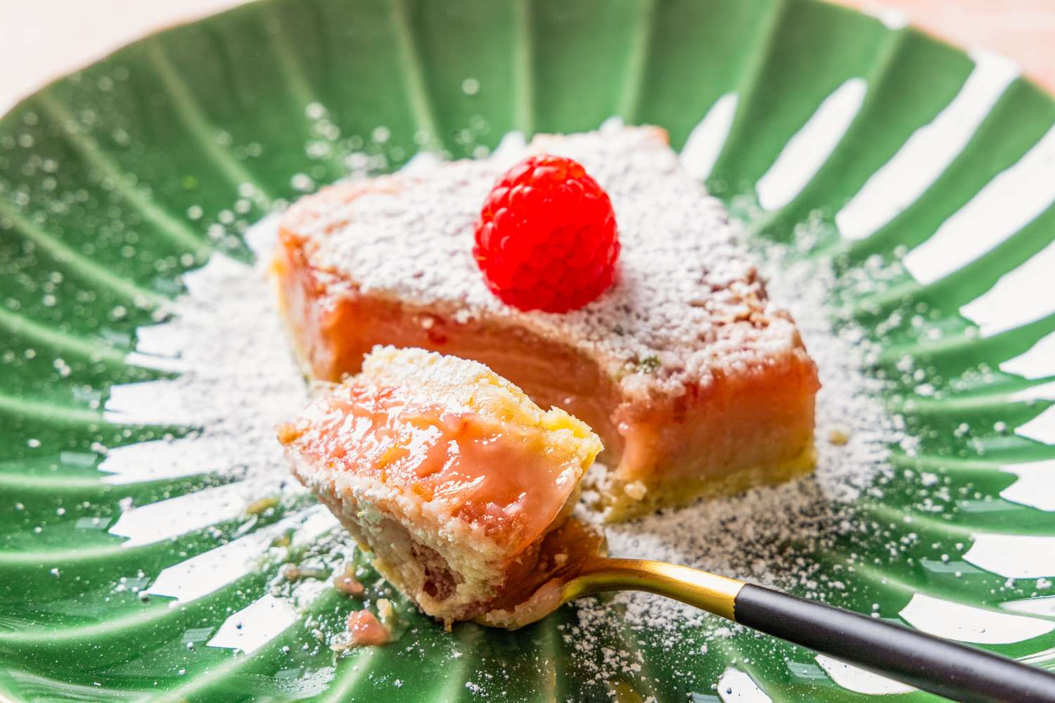 raspberry lime rickey bar on a plate with a piece of the bar broken off using a fork