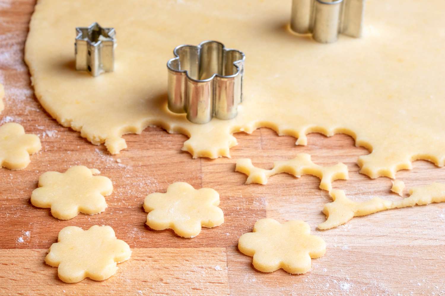 Sugar cookies being cut with a flour cutter