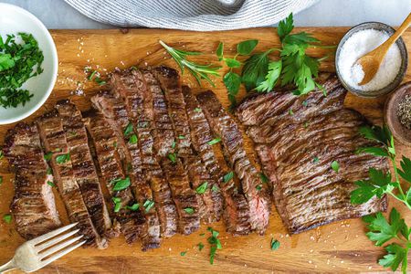 How to Cook Skirt Steak in a Pan - sliced steak with herbs on top