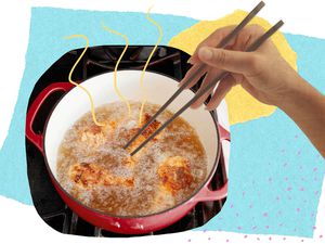 Woman with chopsticks picking up fried chicken