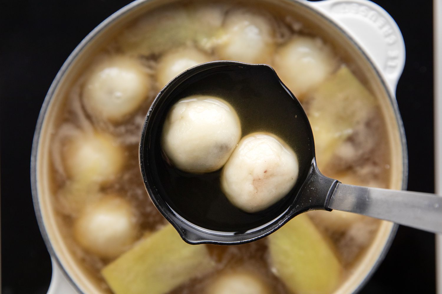 Ladle with Two Rice Balls Raised, and in under It, a Pot Filled with More Red Bean Tangyuan 
