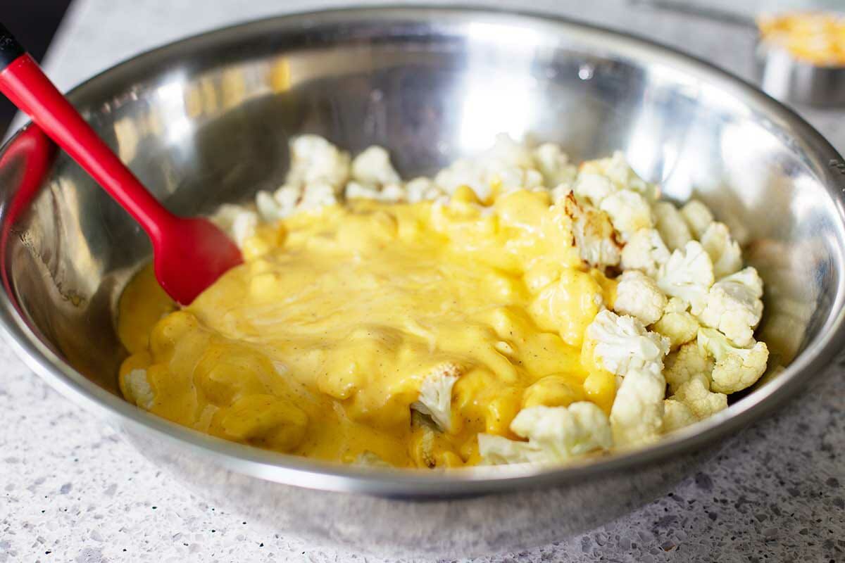 Cheese sauce poured over chopped cauliflower to make Easy Cauliflower Bake.