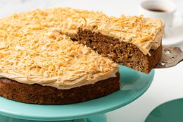 Coffee Coconut Banana Bread Cake on a Cake Platter With a Cut Slice Lifted Using a Pie Server