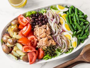 A platter with a Nicoise salad ready to be dressed and served