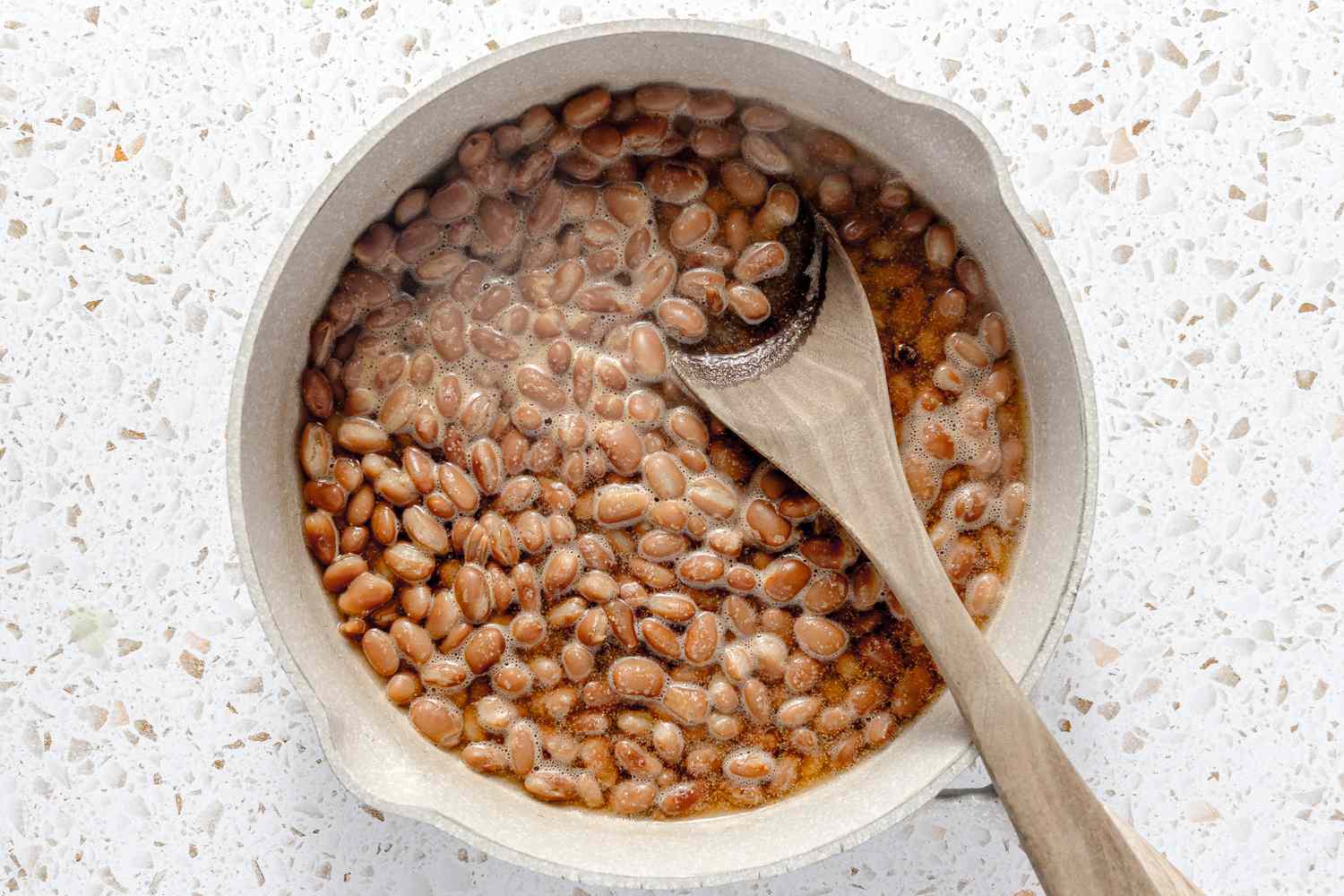 Pinto Beans in a Dutch Oven With a Wooden Spoon for Rice and Beans Burritos Recipe