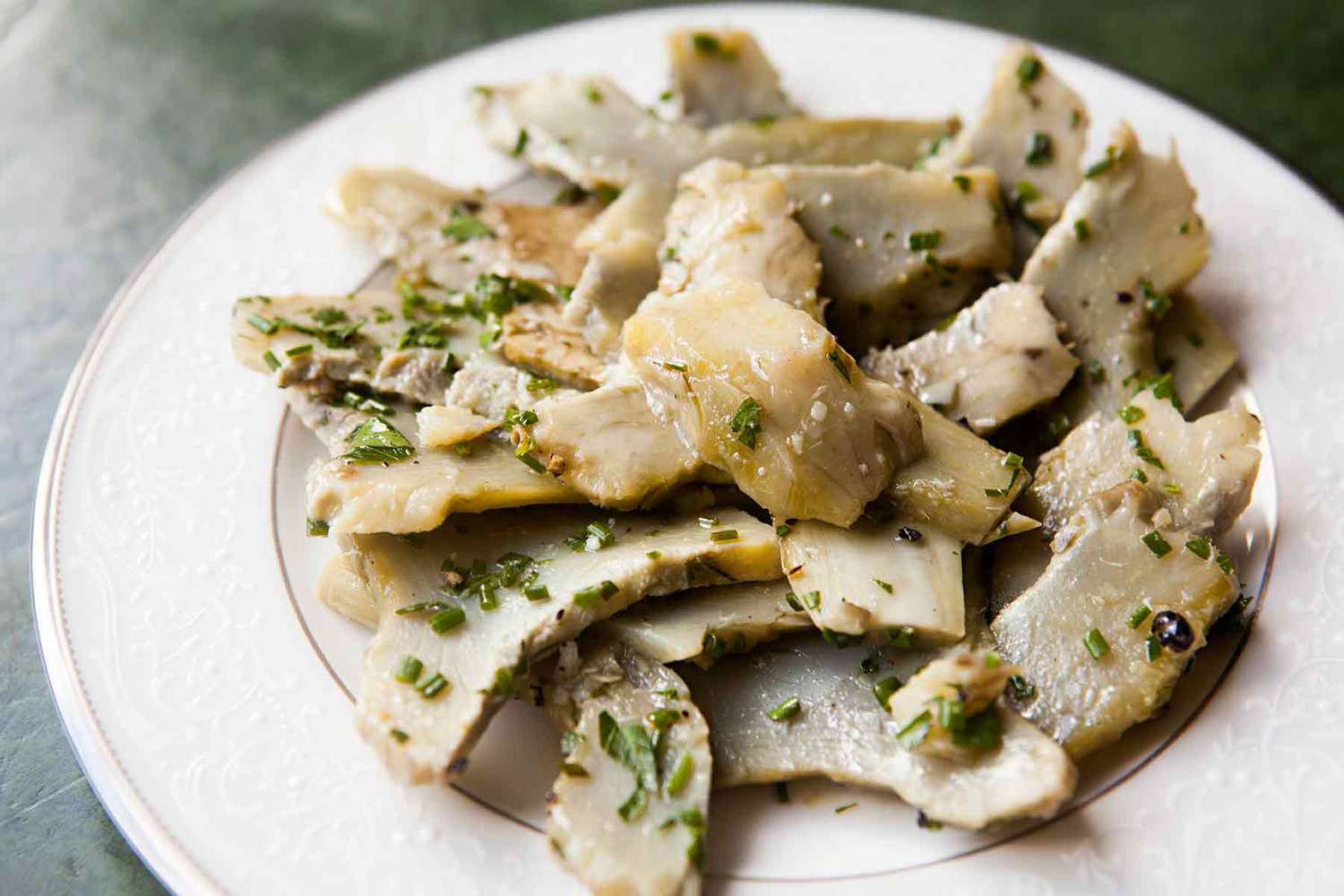 A plate of oil poached artichokes, sliced and ready to serve