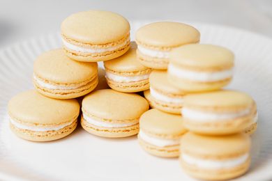 Lemon buttercream macarons set on top of each other on a plate.