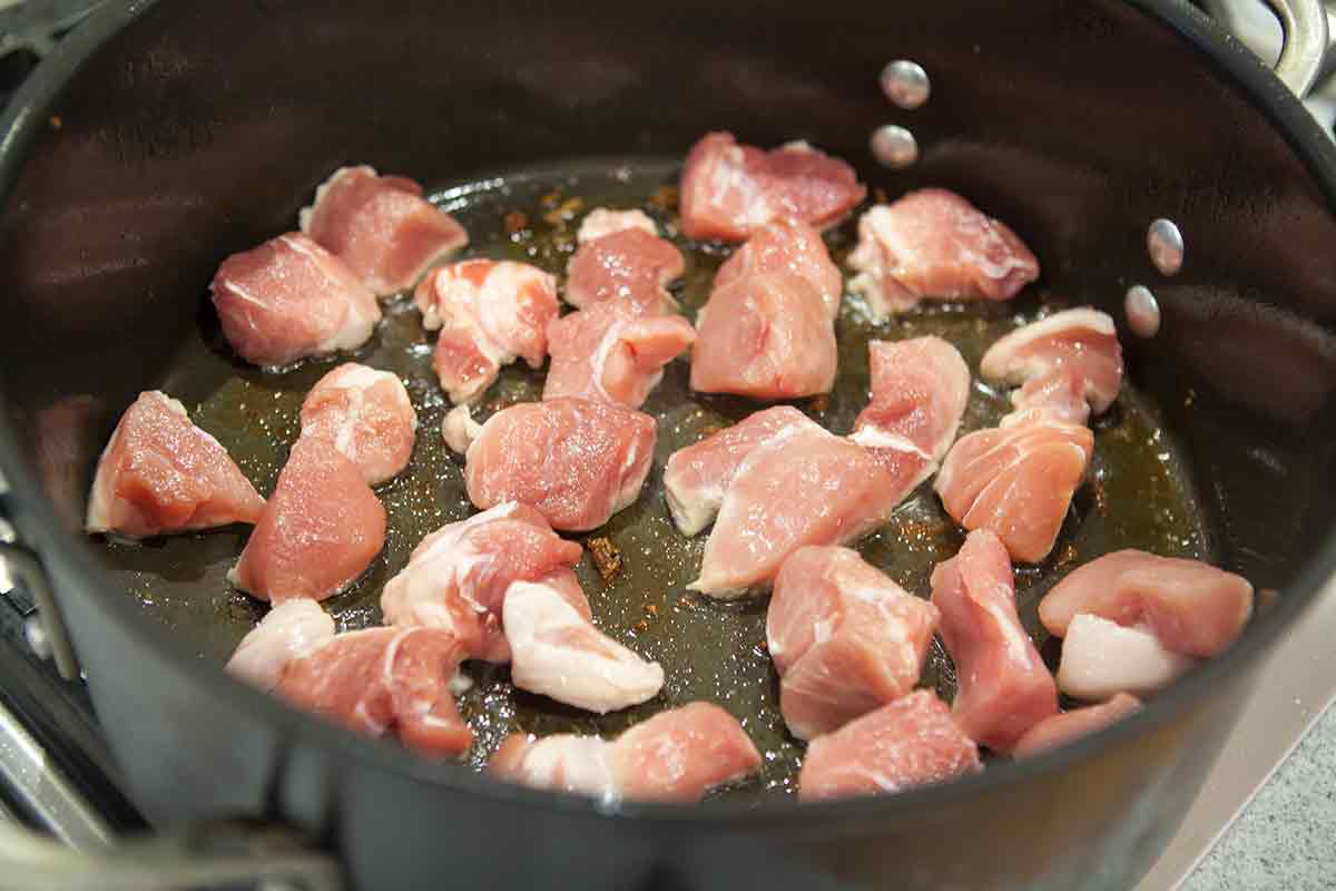 Pork chunks browning in a pot