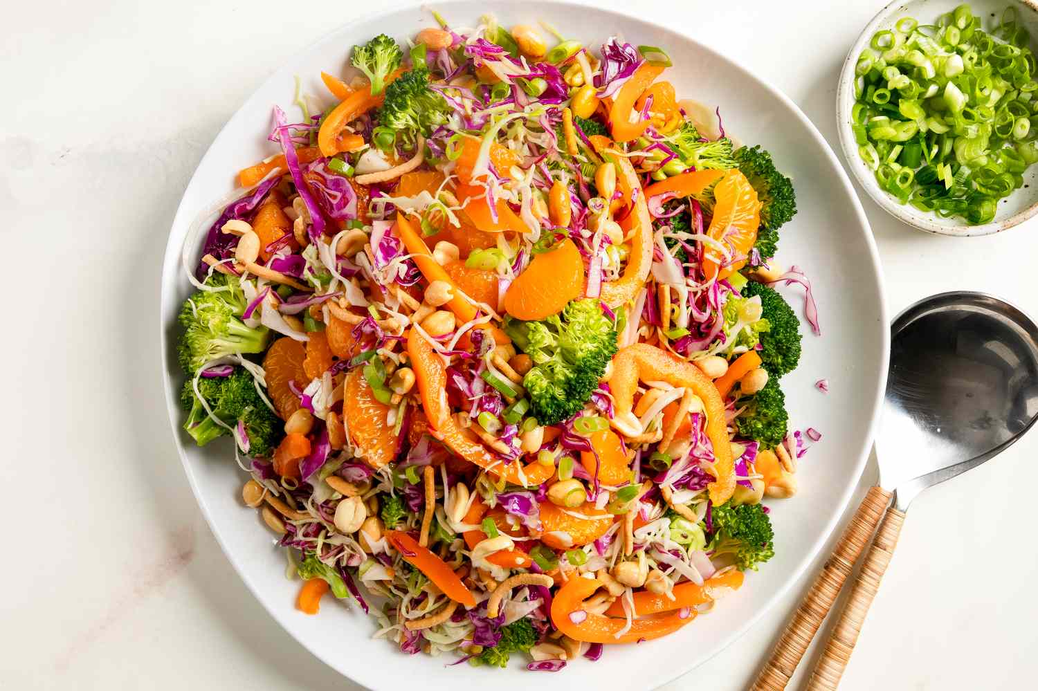 A bowl of broccoli crunch salad with vegetables and orange slices