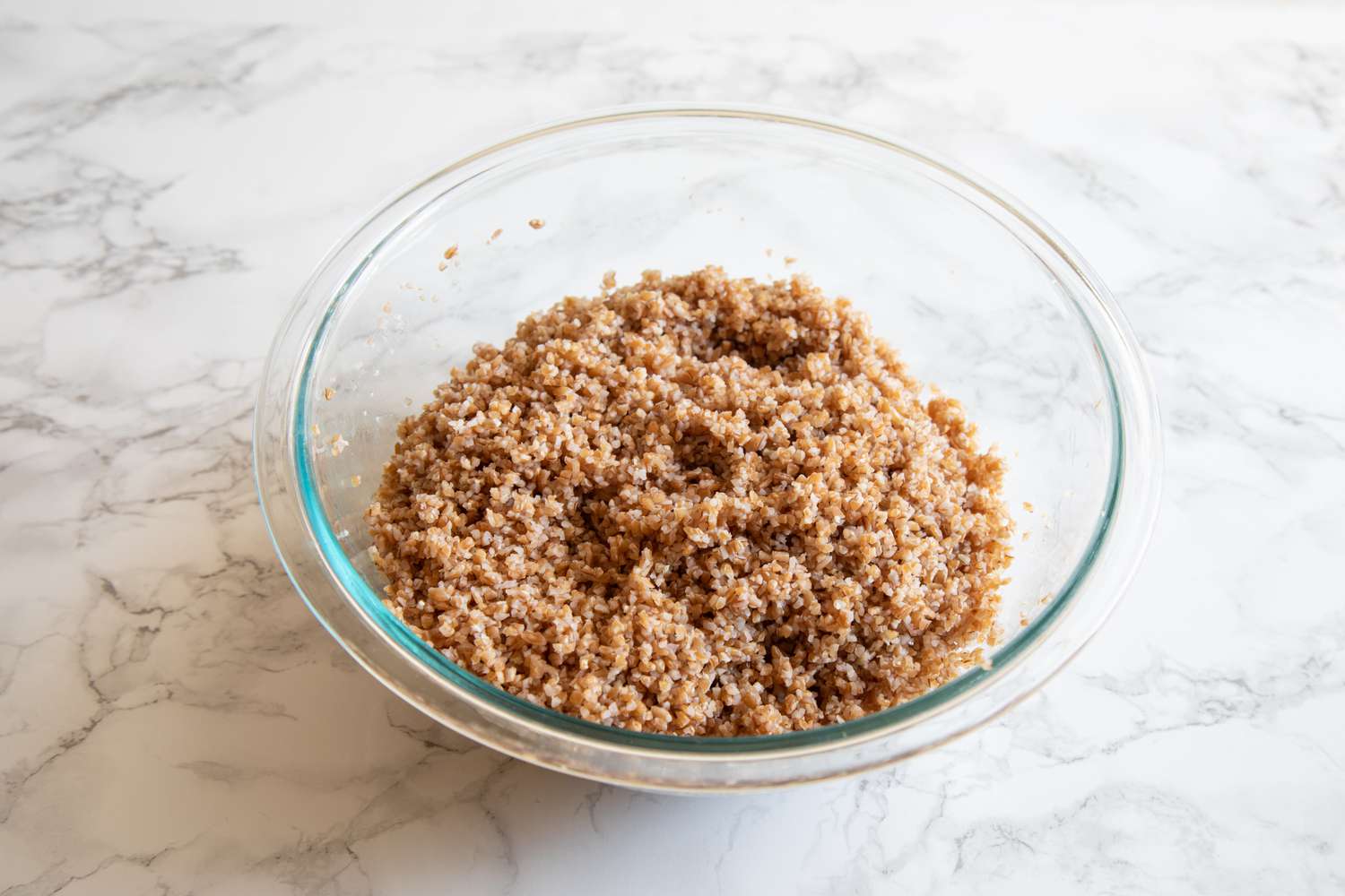 A glass bowl with bulgur to make a tabbouleh recipe.