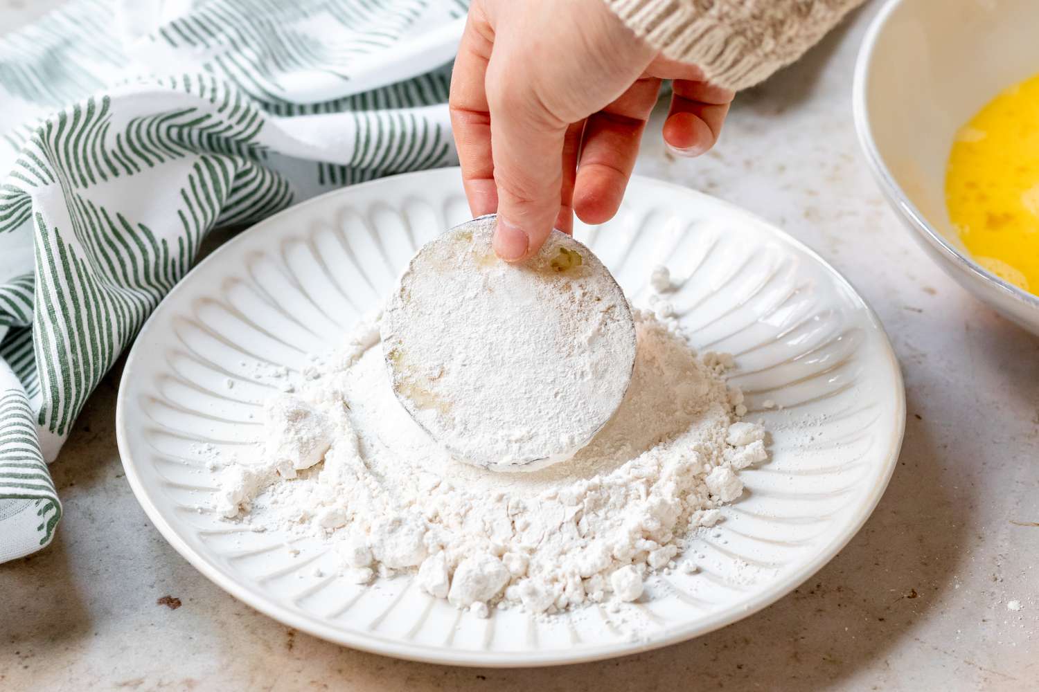 Dipping a sliced eggplant in flour