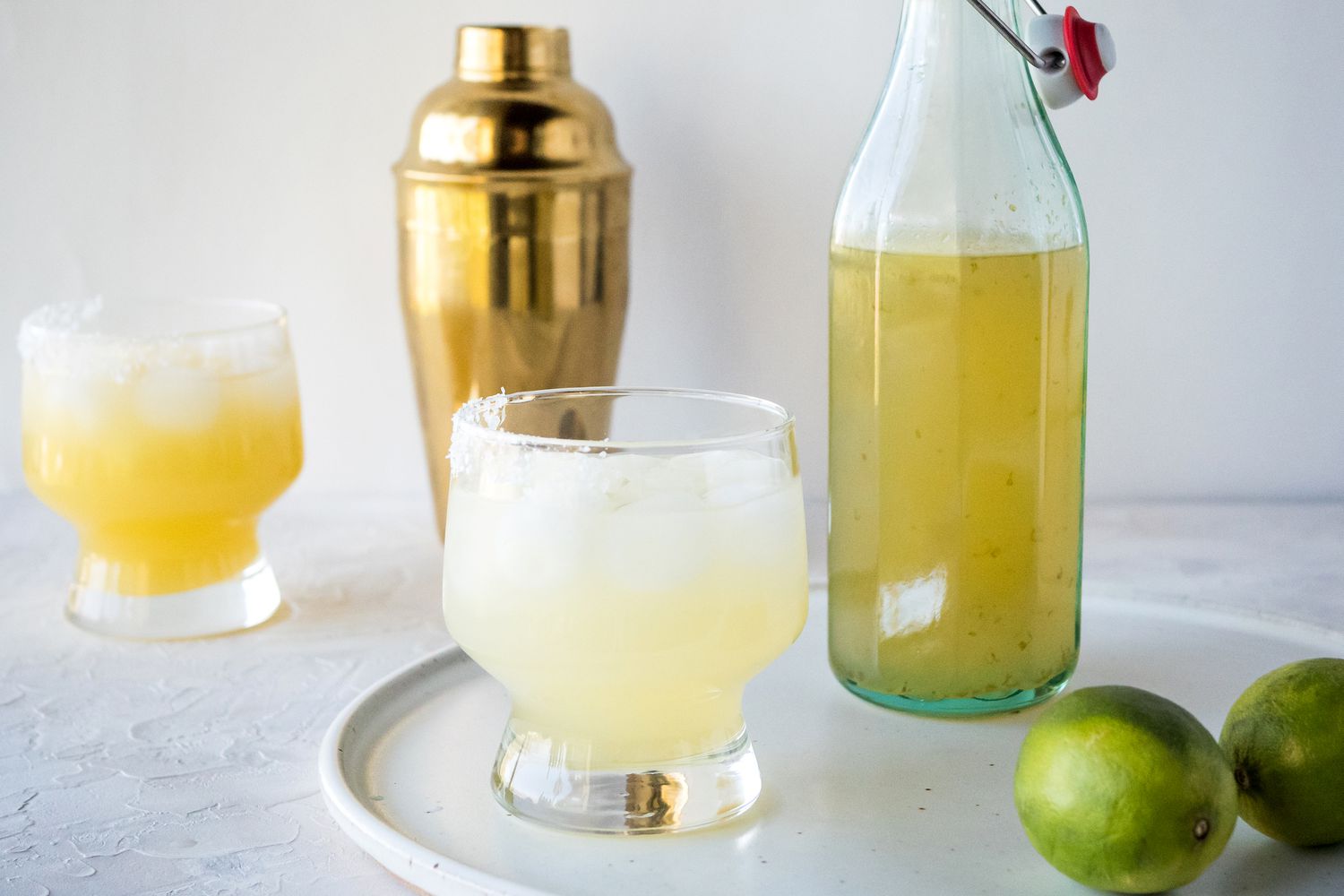 Side view of a margarita and a jar of homemade margarita mix.