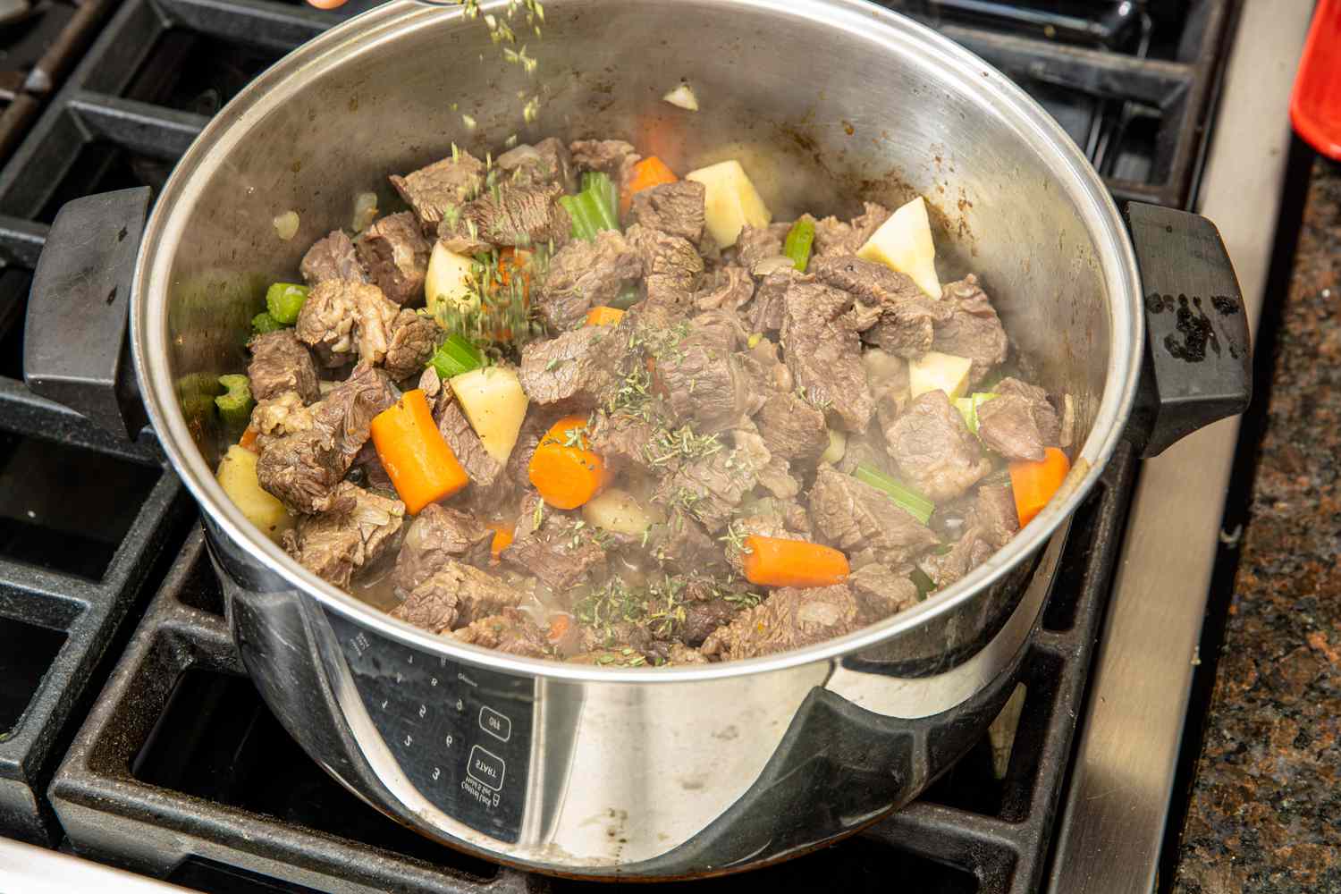 Beef Stew Ingredients Mixed Together in the Pot on the Stove and Seasoned with Herbs