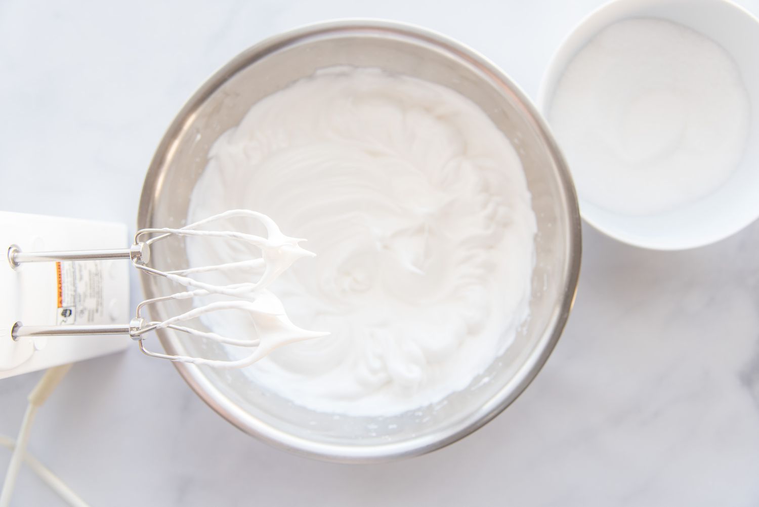 Beating egg whites until fluffy to make Brazo Gitano (Spanish Roll Cake).