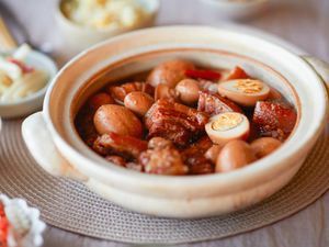 Pork belly and eggs braised in sweet coconut water in a bowl.