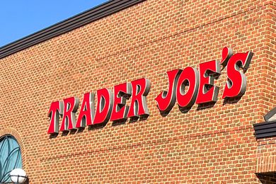 Trader Joe's storefront sign on a brick wall, blue sky background