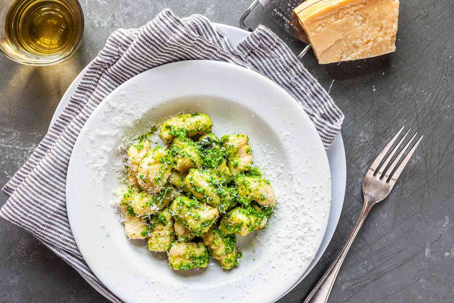 Potato Gnocchi tossed with pesto sauce in a serving bowl