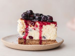 A slice of blueberry cheesecake on a plate.