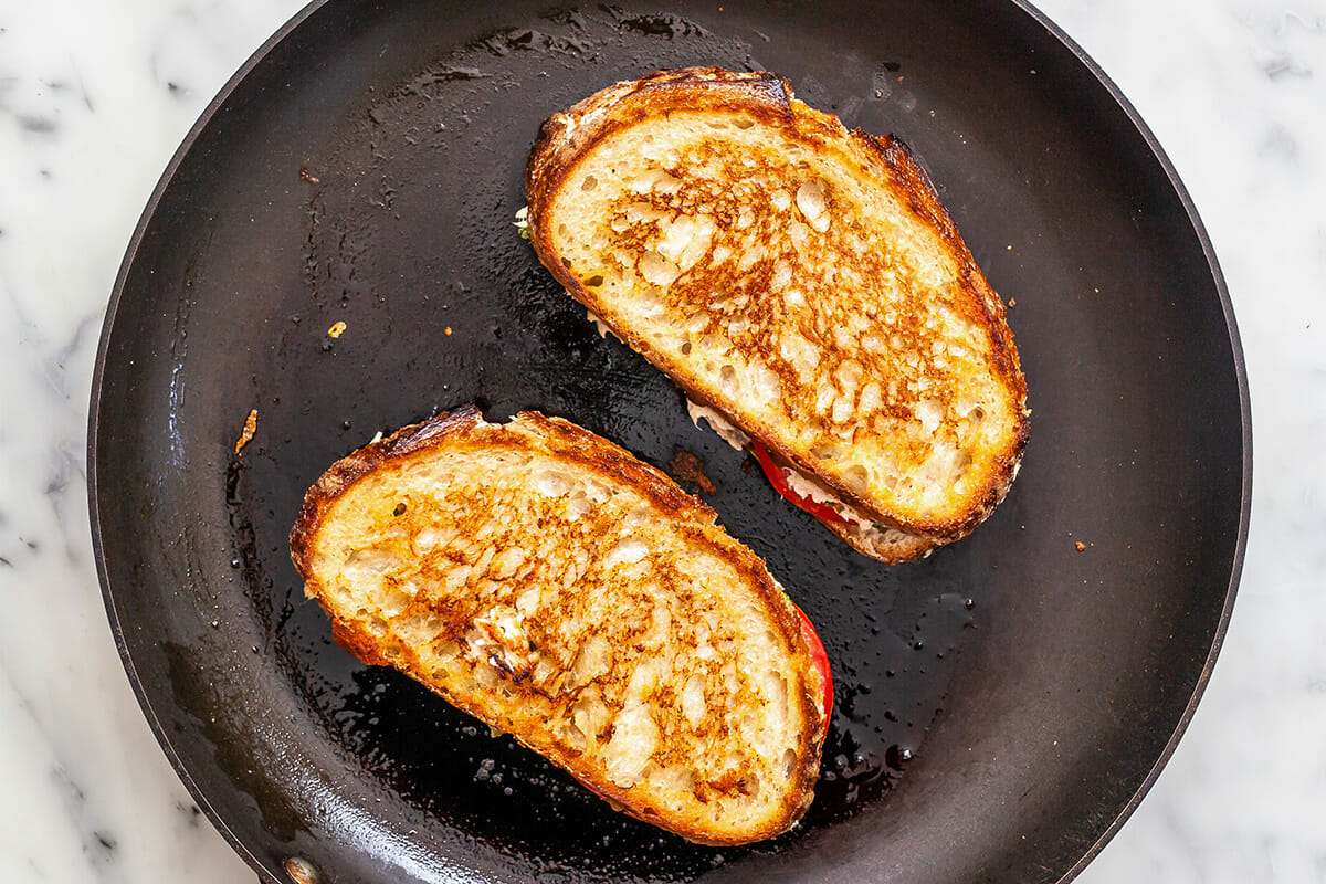 Two of the best tuna melt sandwiches toasted in a cast iron skillet.