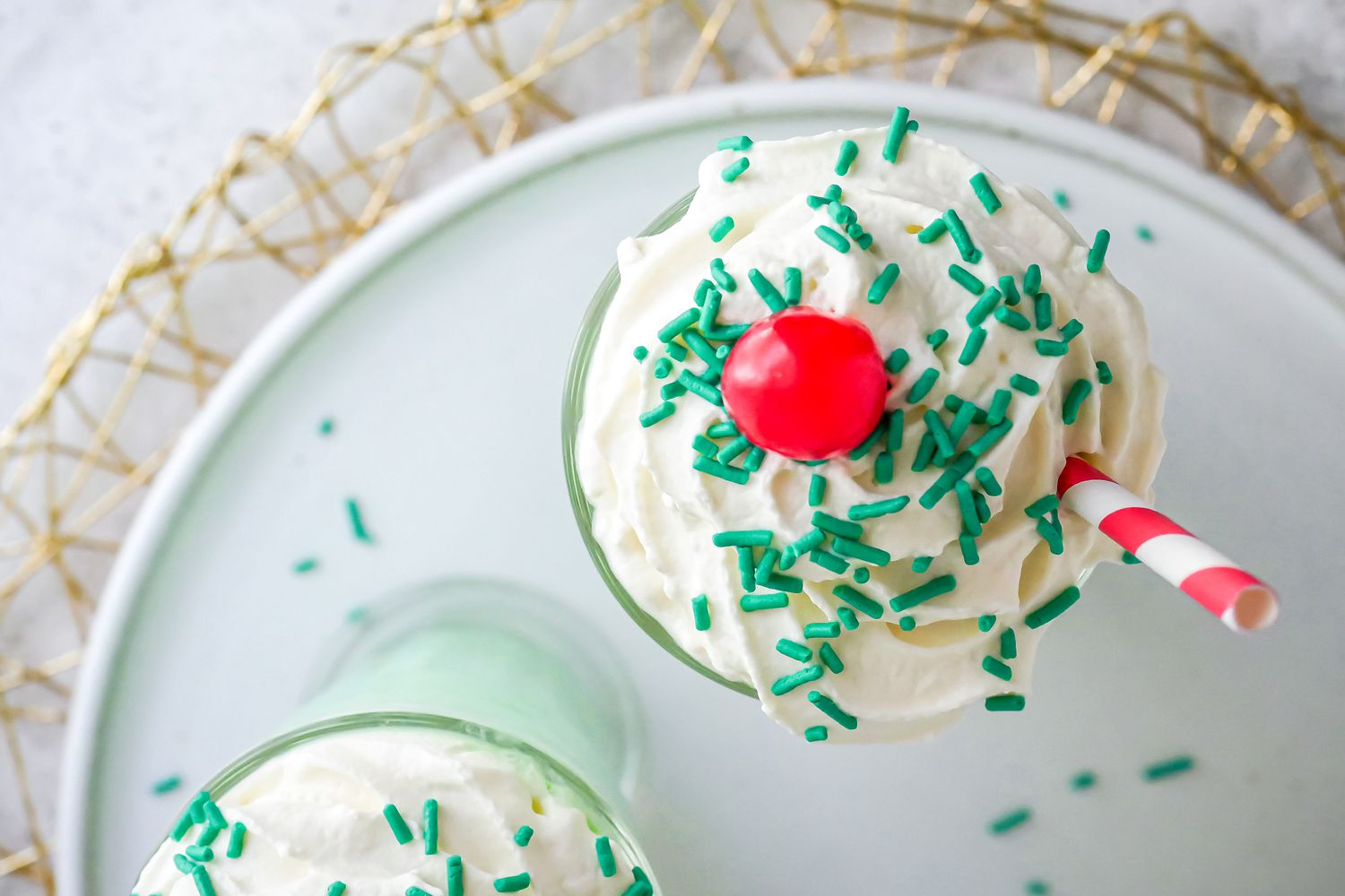 Copycat McDonald’s Shamrock Shake with a straw and cherry.